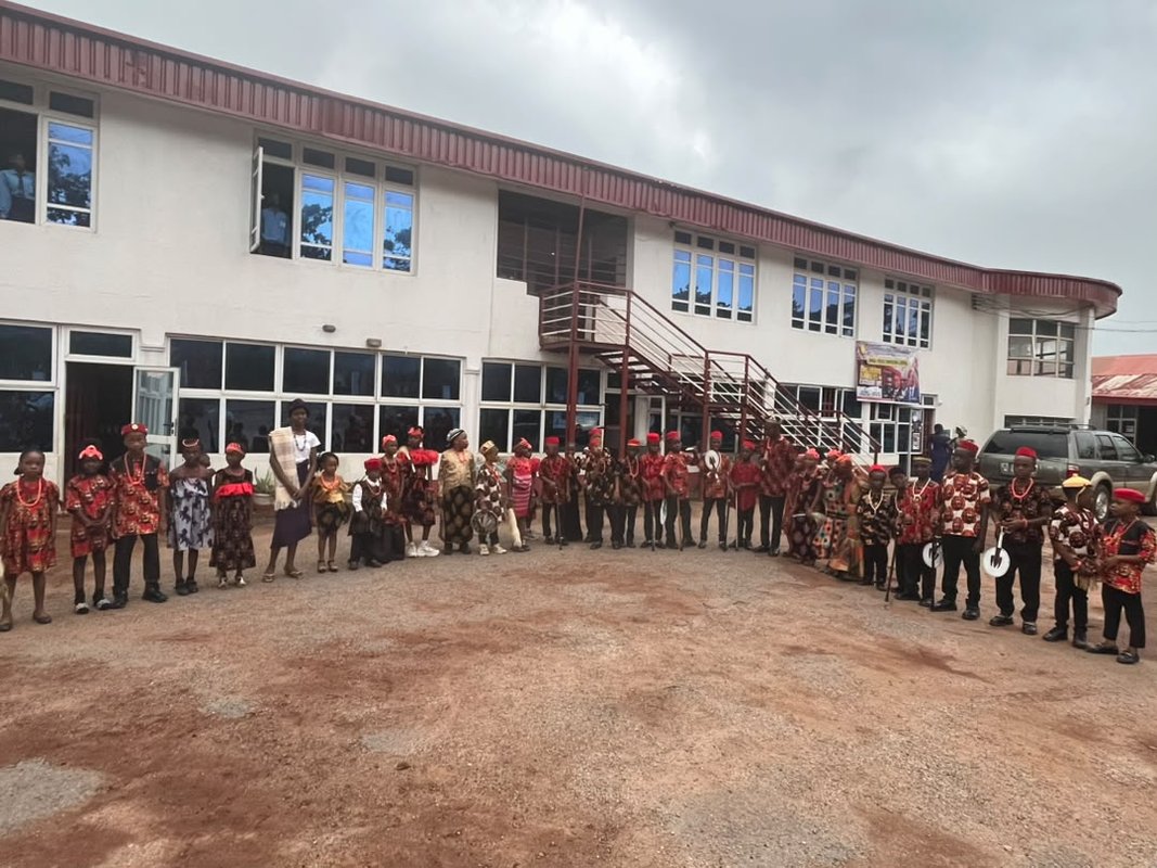 Royal Crystal Academy school building with pupils in cultural attire